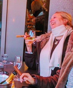 Linn Sovig smoking cigars and drinking champagne